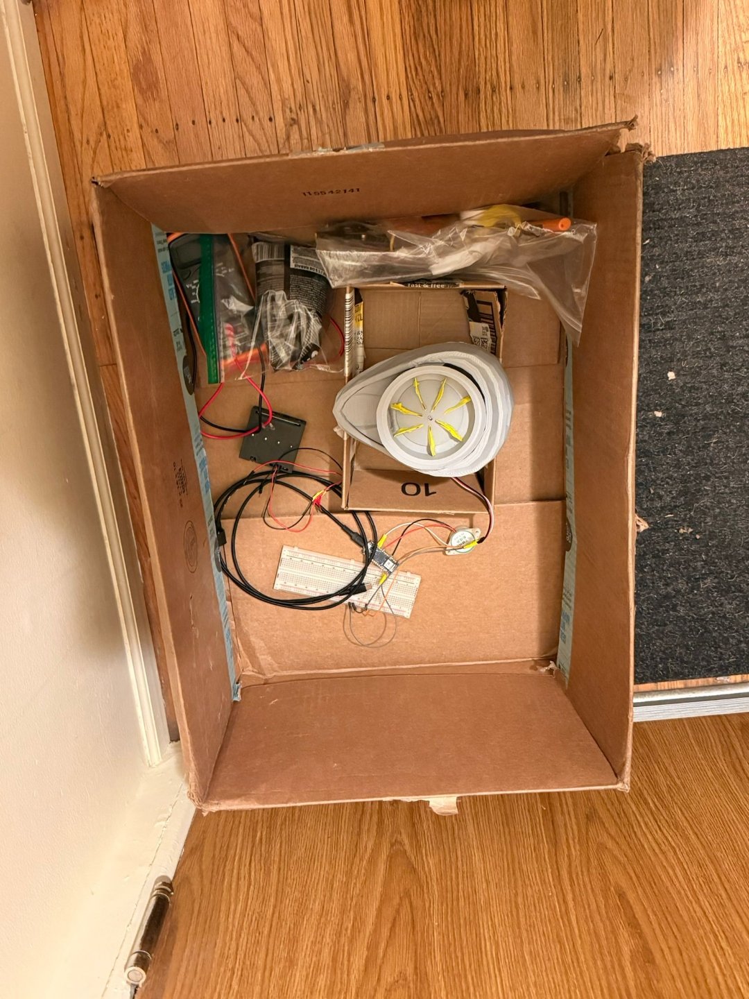 All CuePo prototype parts laid out — 3D-printed components, electronics, housing, and agitator